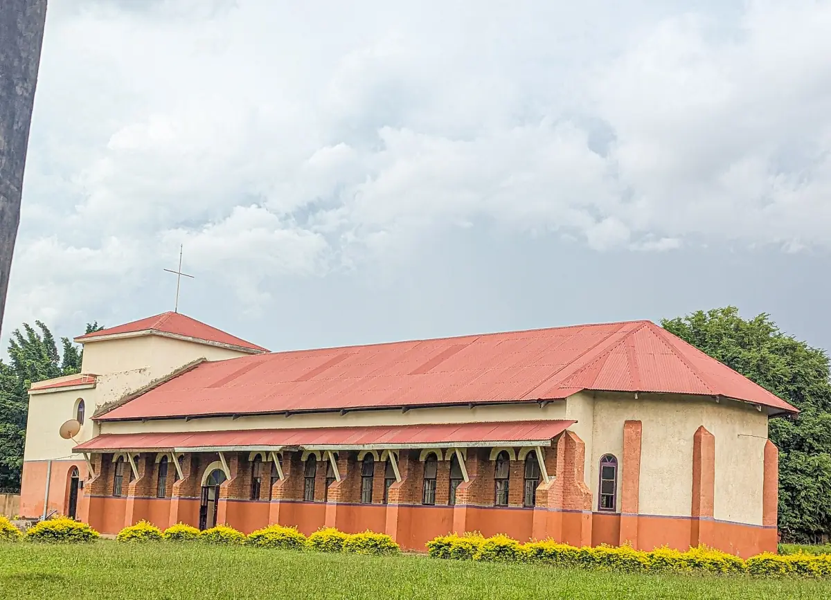 Long cathedral building with a red roof and lawn in Kitgum